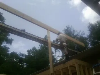 Carpenter setting a ridge beam over a new addition frame — Ice Dam Removal by Roofing Brothers in Osage